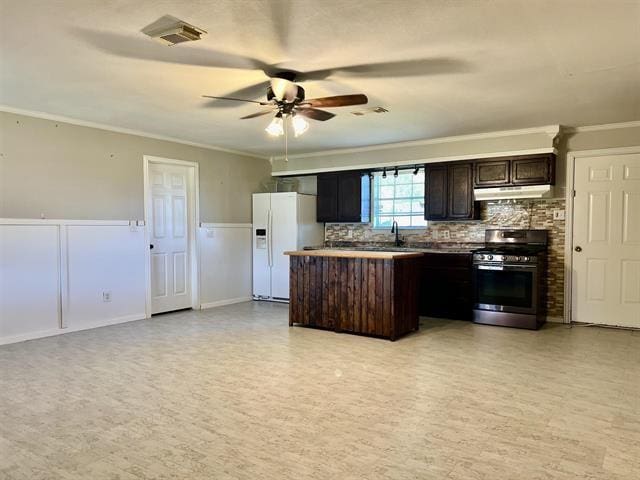 kitchen featuring crown molding, dark brown cabinetry, white fridge with ice dispenser, and stainless steel gas range oven