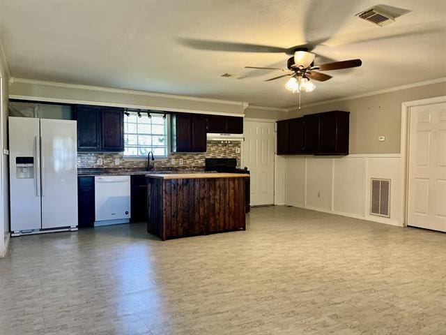 kitchen featuring white appliances, crown molding, ceiling fan, dark brown cabinetry, and tasteful backsplash