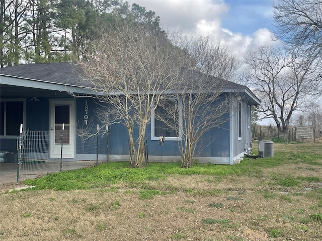 view of property exterior featuring central AC unit and a lawn