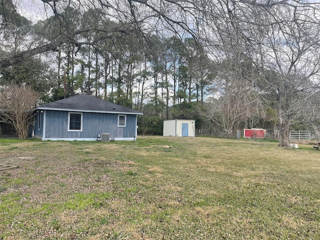 view of yard with central AC and a storage unit