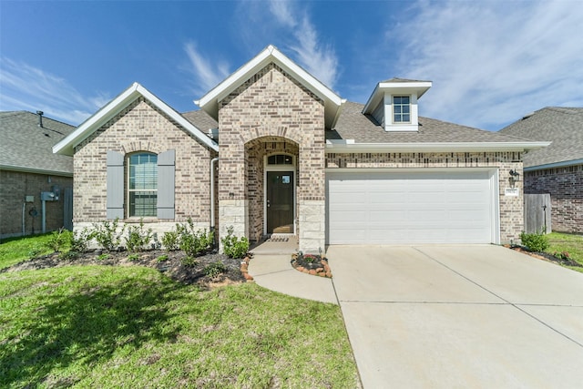 french country inspired facade with concrete driveway, brick siding, and a garage