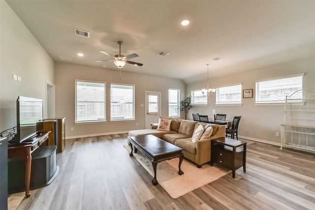 living room featuring ceiling fan with notable chandelier and light hardwood / wood-style floors