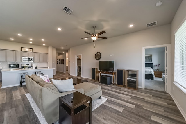 living area with dark wood finished floors, ceiling fan, visible vents, and recessed lighting