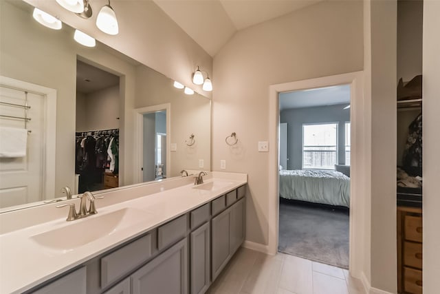 bathroom featuring tile patterned floors, vanity, and vaulted ceiling