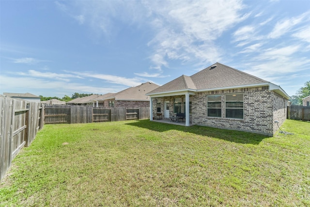 rear view of house with a yard and a patio