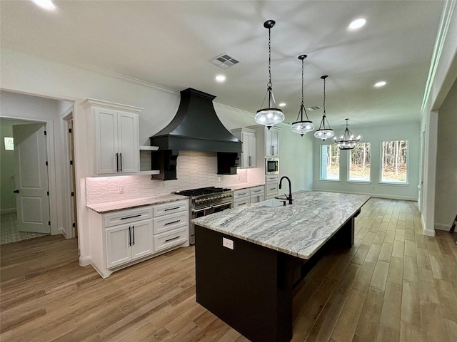 kitchen with stainless steel appliances, custom exhaust hood, a large island, and white cabinets