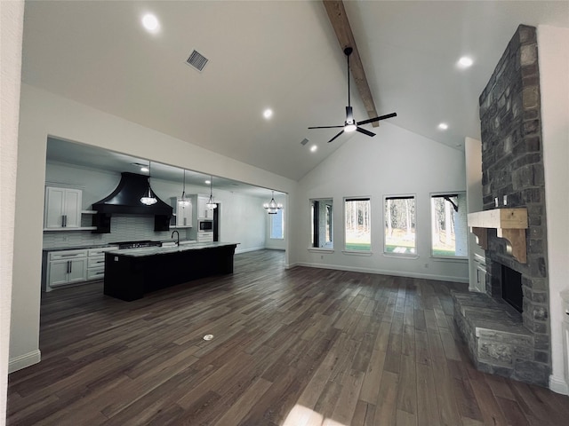 living room with beam ceiling, sink, a fireplace, and dark hardwood / wood-style floors