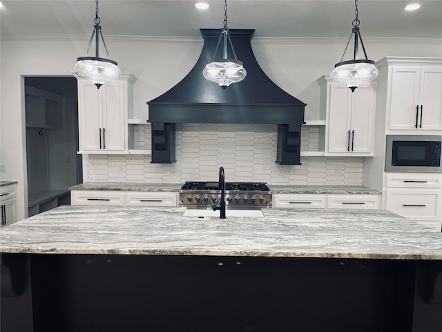 kitchen featuring built in microwave, hanging light fixtures, a kitchen island with sink, and custom exhaust hood