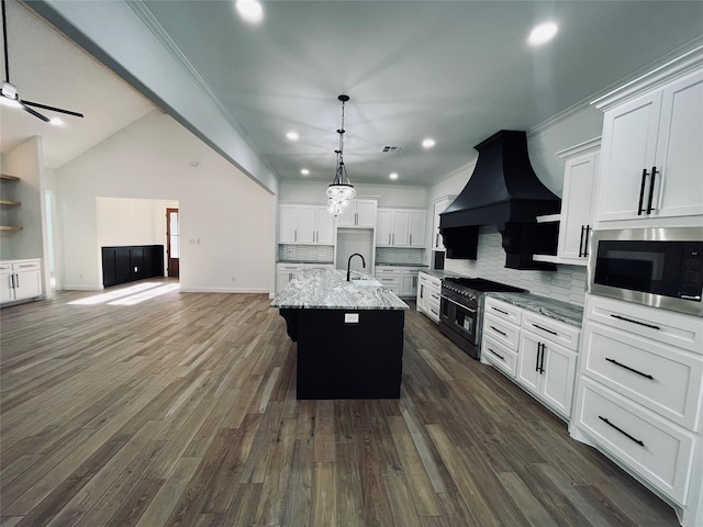 kitchen featuring sink, custom exhaust hood, an island with sink, stainless steel appliances, and white cabinets