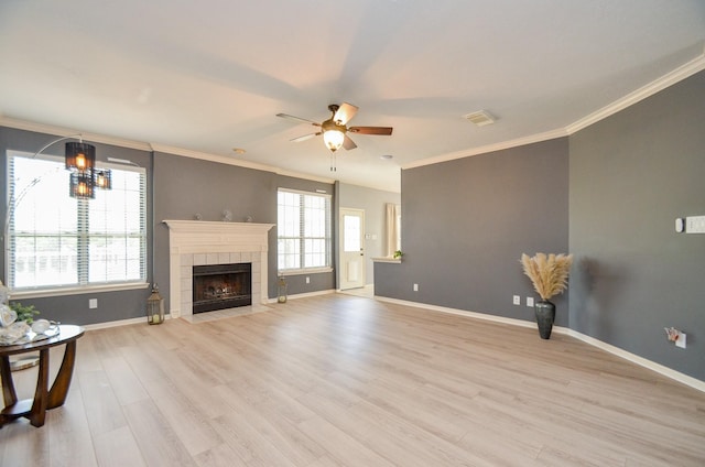 living room with a tile fireplace, crown molding, light hardwood / wood-style flooring, and ceiling fan