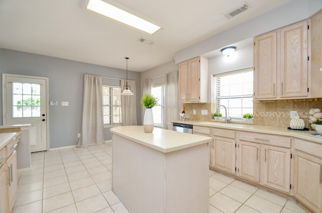 kitchen with backsplash, dishwasher, a center island, and a healthy amount of sunlight