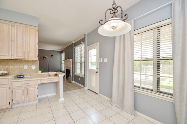 kitchen with backsplash, light brown cabinets, light tile patterned floors, and pendant lighting