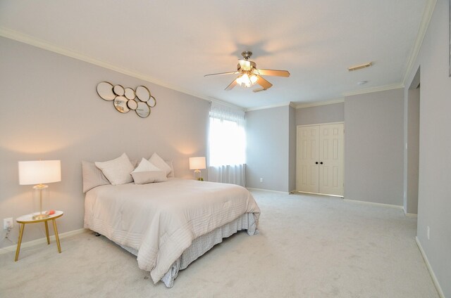 bedroom with light carpet, a closet, ceiling fan, and ornamental molding