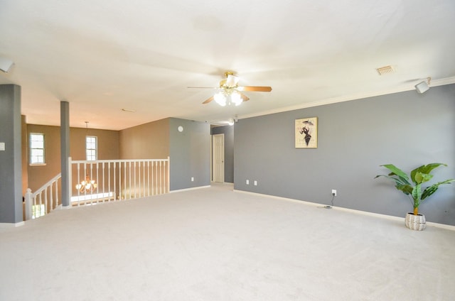 carpeted spare room with ceiling fan and ornamental molding