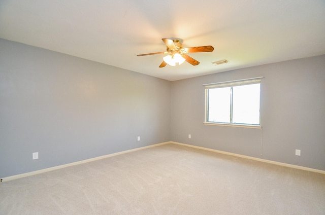 empty room featuring ceiling fan and light carpet