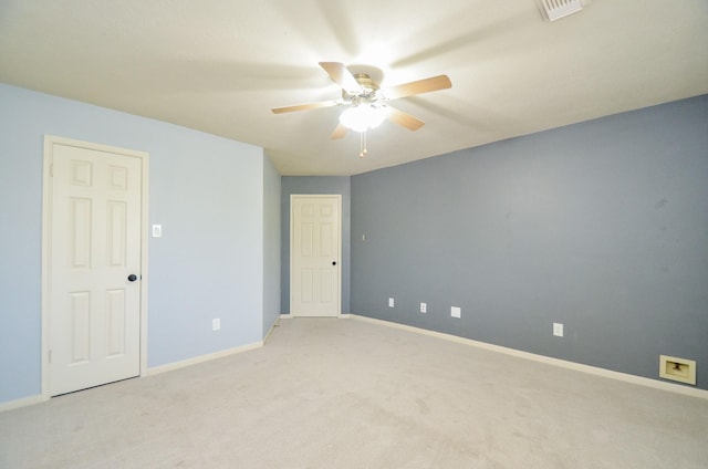 spare room with ceiling fan and light carpet