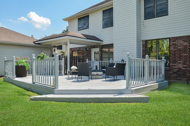 back of house with a yard, an outdoor fire pit, and a wooden deck