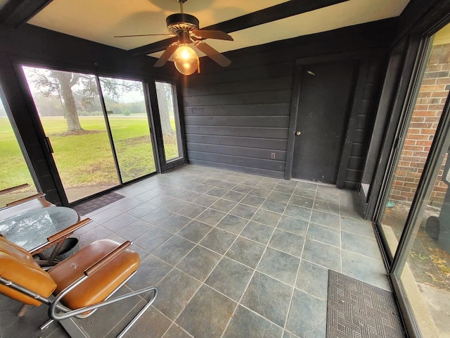 unfurnished sunroom with ceiling fan