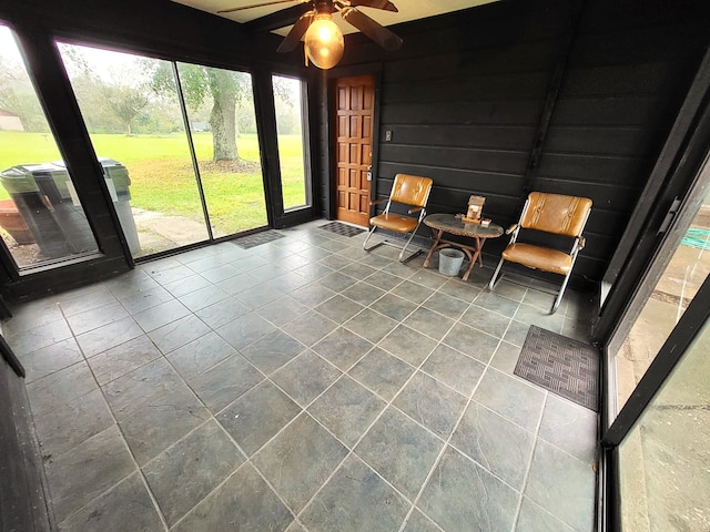 unfurnished sunroom featuring ceiling fan