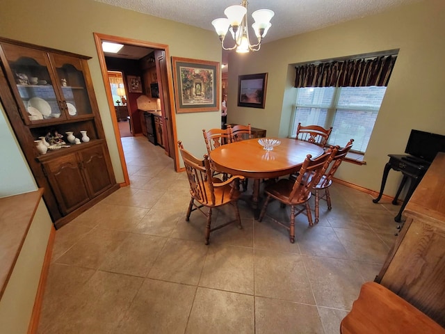 dining area featuring light tile patterned floors, a textured ceiling, and an inviting chandelier