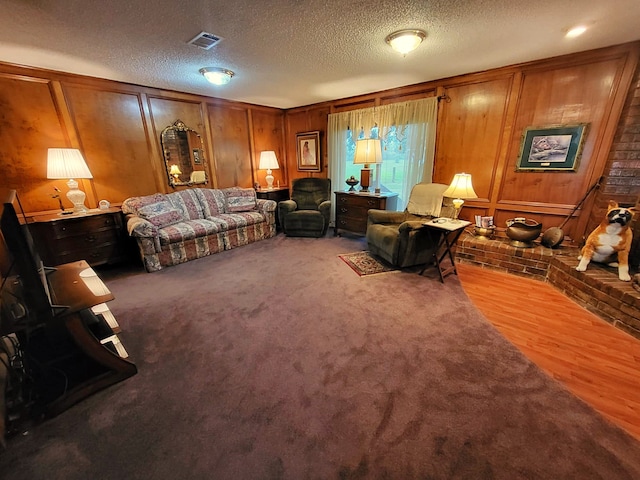 interior space with carpet flooring, wood walls, and a textured ceiling