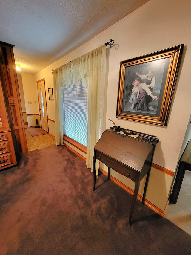 corridor featuring carpet flooring and a textured ceiling