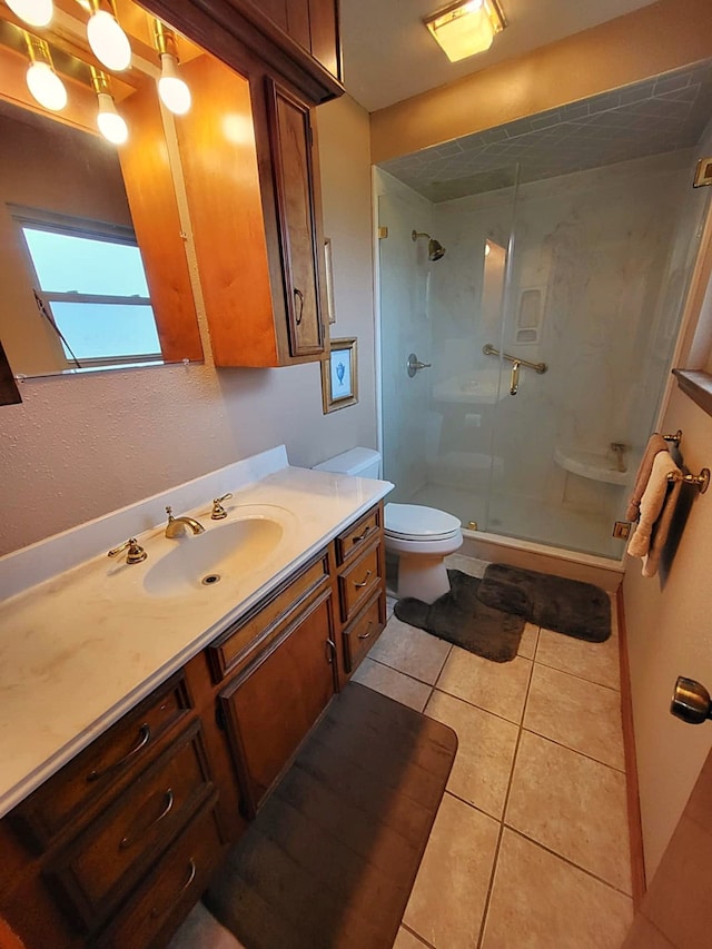 bathroom with tile patterned floors, vanity, toilet, and walk in shower