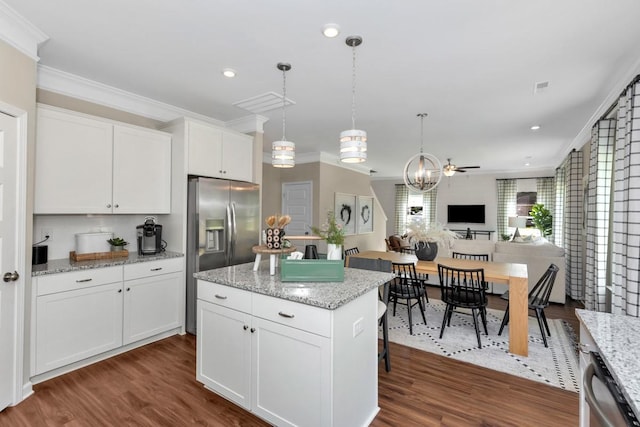 kitchen with dark hardwood / wood-style floors, pendant lighting, white cabinets, a center island, and light stone countertops