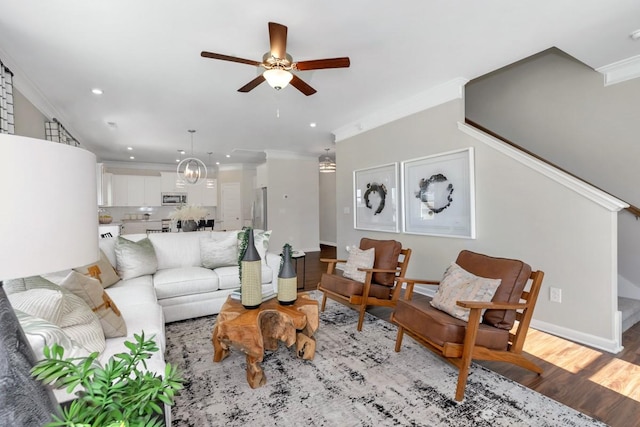 living room with ornamental molding, ceiling fan, and light hardwood / wood-style floors