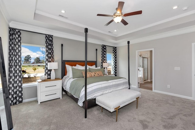 carpeted bedroom featuring a tray ceiling, ornamental molding, and ceiling fan