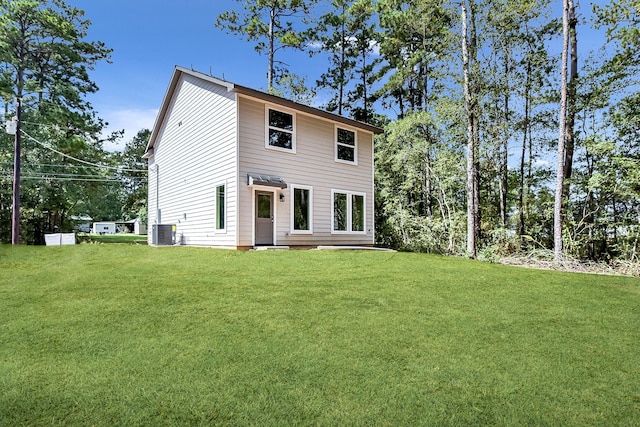 rear view of property with a yard and central AC unit