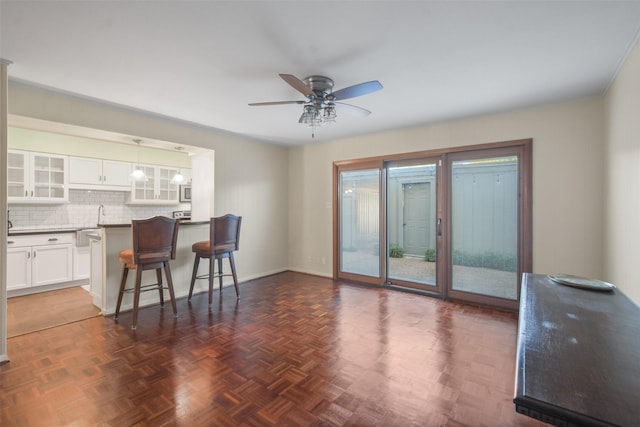 living room with dark parquet flooring and ceiling fan