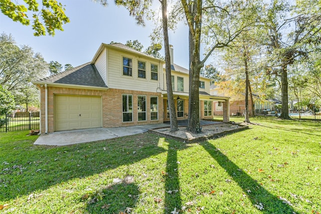 back of house featuring a yard, a patio, and a garage