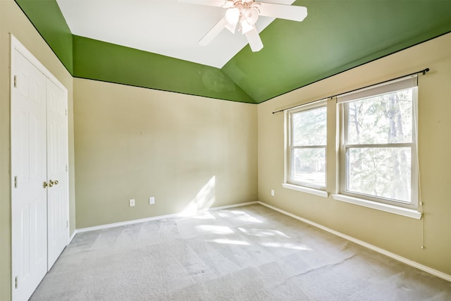 unfurnished bedroom with light carpet, ceiling fan, and lofted ceiling