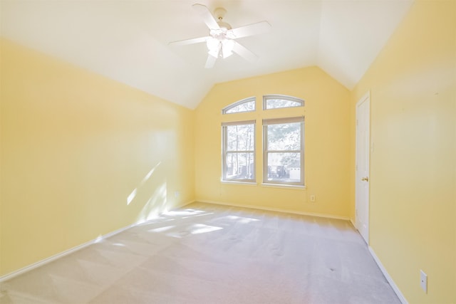 empty room featuring light colored carpet, vaulted ceiling, and ceiling fan