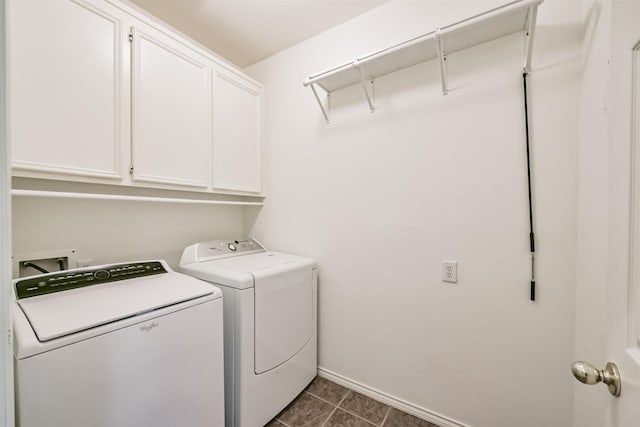 laundry area with dark tile patterned floors, cabinets, and separate washer and dryer