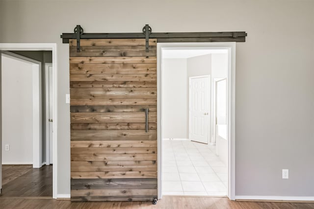 interior space with a barn door and hardwood / wood-style flooring