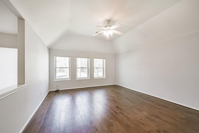 empty room with dark hardwood / wood-style floors, vaulted ceiling, and ceiling fan