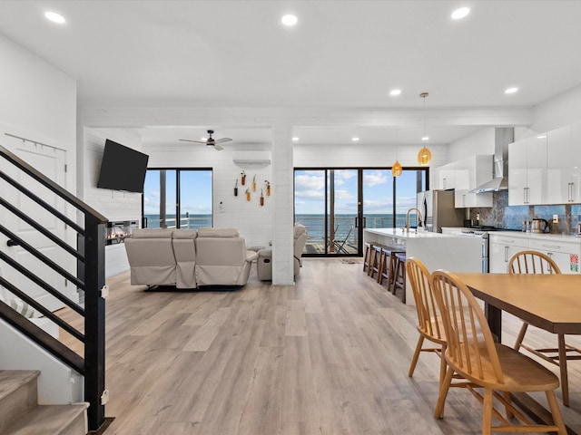 dining space featuring light wood-type flooring and ceiling fan