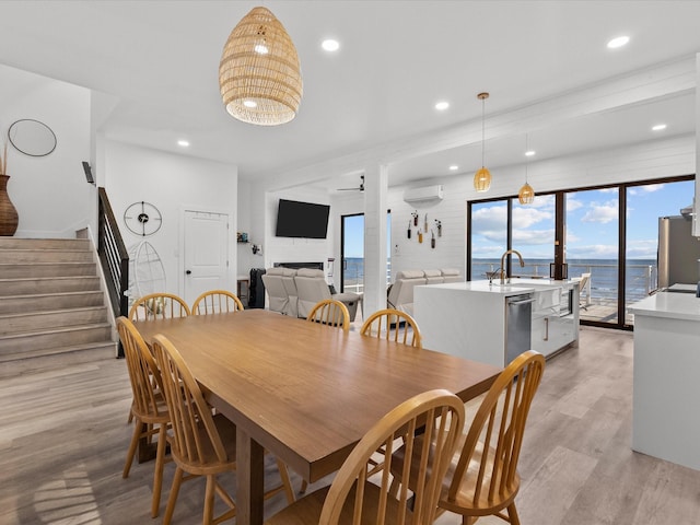 dining room featuring ceiling fan, sink, and light hardwood / wood-style flooring