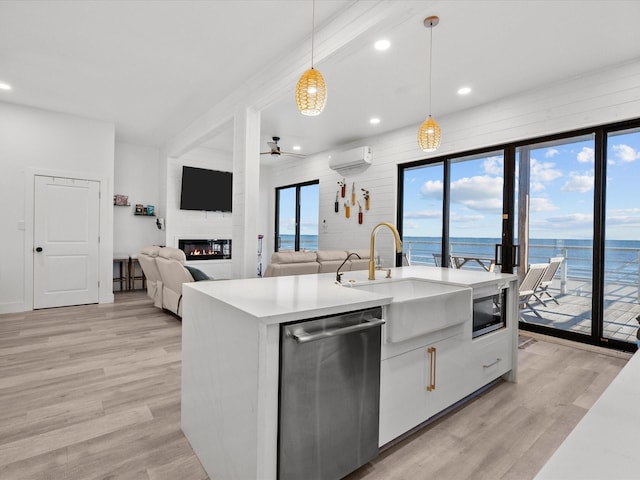 kitchen with white cabinetry, ceiling fan, an AC wall unit, decorative light fixtures, and appliances with stainless steel finishes