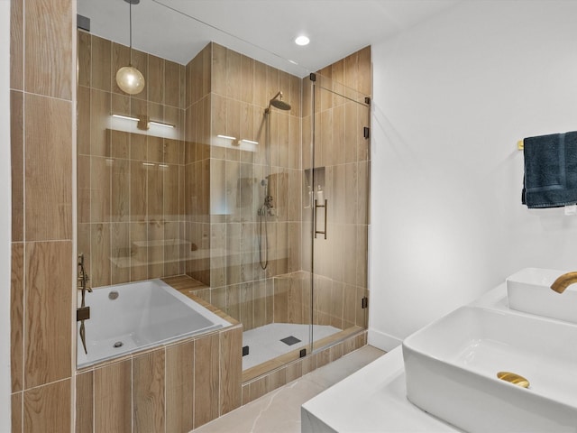 bathroom featuring tile patterned flooring, shower with separate bathtub, and double sink