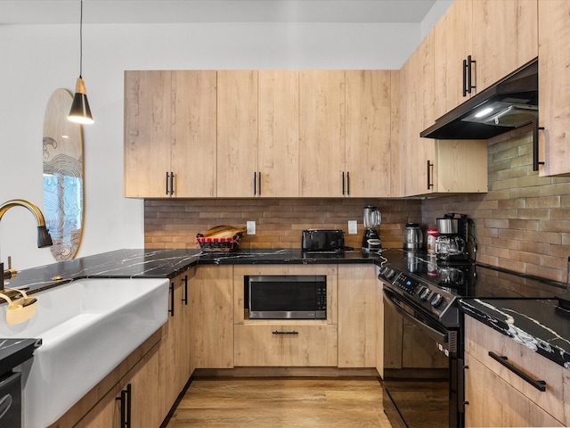 kitchen featuring light brown cabinets, light hardwood / wood-style flooring, black electric range oven, and stainless steel microwave