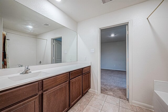 bathroom with tile patterned flooring, vanity, and a washtub