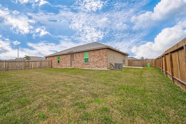 rear view of house with a yard and cooling unit