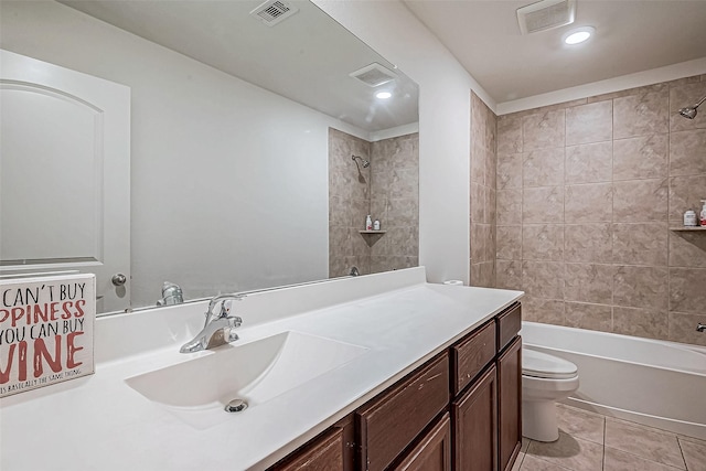 full bathroom with tile patterned flooring, vanity, toilet, and tiled shower / bath