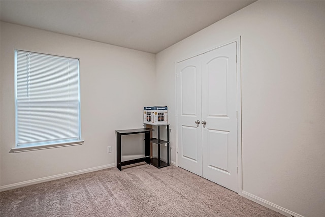 bedroom featuring light carpet and a closet