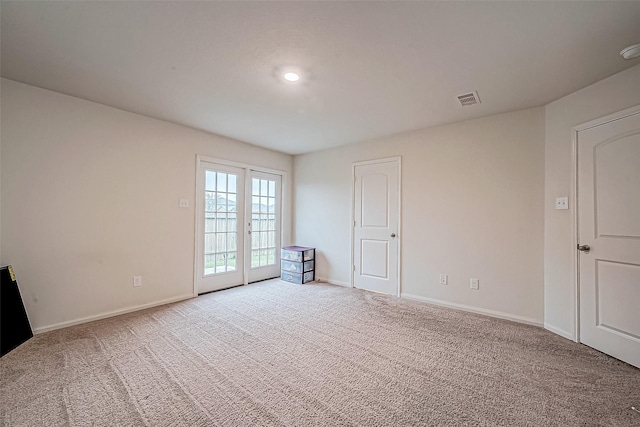 carpeted spare room with french doors