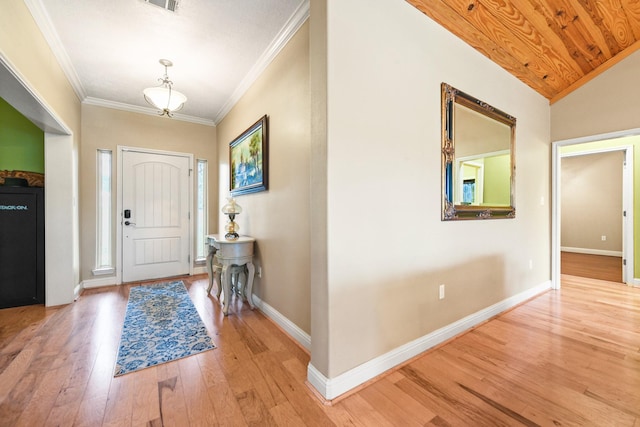 foyer with ornamental molding, hardwood / wood-style flooring, and lofted ceiling