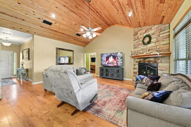 living room featuring ceiling fan, high vaulted ceiling, light hardwood / wood-style flooring, wooden ceiling, and a stone fireplace